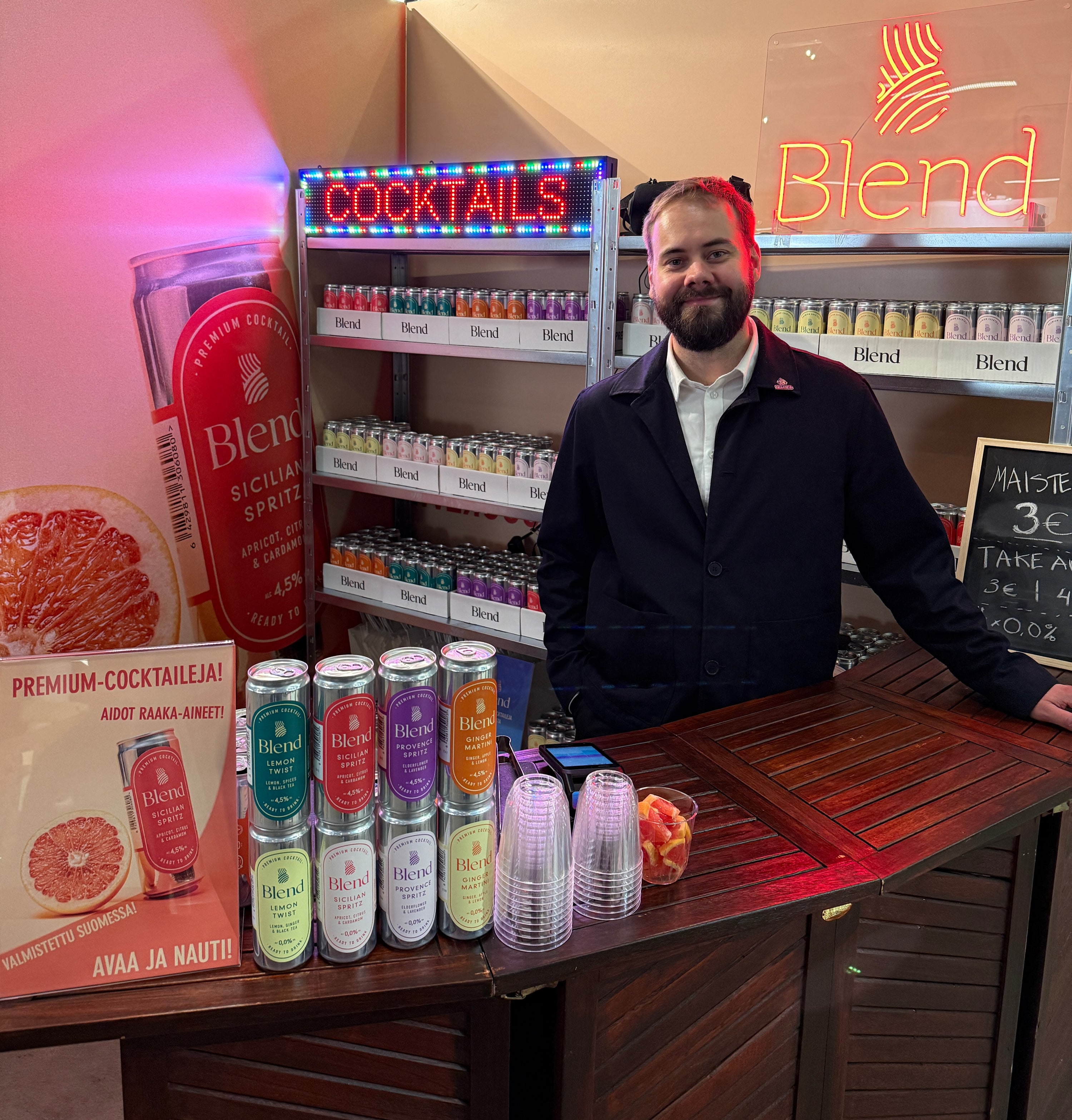 Risto Blend-baarin takana, takana cocktail- ja blend-kyltit. Edustalla baaritiski ja blend-tölkkejä